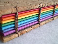 a close up of many different colored corks on a table with white surface and grey background