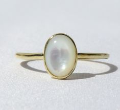 Elegant, simple and truly a classic piece. This mother of pearl ring is made from 14k solid gold or 14k solid white gold material. Set with a natural mother of pearl stone. Each pearl is unique and natural. Whether you're buying this beautiful pearl ring as a gift or for yourself, it will bring forth new beginnings and good luck. Handmade in Los Angeles, CA! Fast Shipping: It will take 1-3 business days to send out your item Packaging: Comes in an upgraded gift box, ready for gift-giving! Pearl Classic White Gold Birthstone Ring With Polished Finish, Timeless Oval Rings With High Luster, White Gold Solitaire Opal Ring Gift, 14k White Gold Moonstone Promise Ring, Elegant Round Birthstone Ring With Polished Finish, Classic Yellow Gold Moonstone Ring With Polished Finish, 14k White Gold Birthstone Ring With Polished Finish, Anniversary Oval Cabochon Opal Ring With Polished Finish, Anniversary Opal Ring With Oval Cabochon