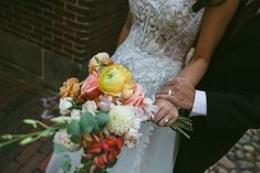 the bride and groom are holding each other's hands with flowers in their bouquet