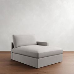 a couch sitting on top of a wooden floor next to a white wall and wood floor