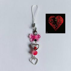 a heart shaped keychain with two charms attached to it's sides and a photo of a woman on the other side