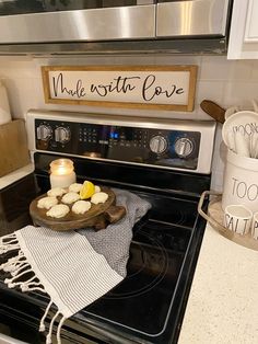 a stove top oven sitting inside of a kitchen next to a wooden sign that says make mitt love