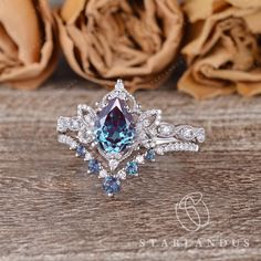 a blue and white diamond ring on top of a wooden table with roses in the background