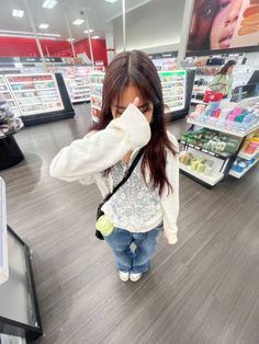 a woman standing in a store looking at her cell phone