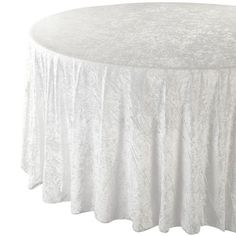 a round table with white linens on the top and an elegant design at the base