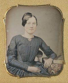 an old photo of a woman in blue dress