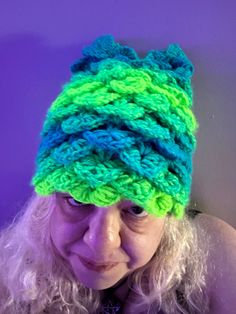 a woman wearing a green and blue knitted hat