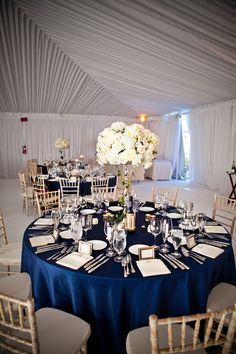 a table is set with white flowers and place settings