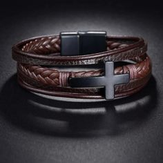 "This stunning brown braided Genuine leather bracelet features 5 tiers of 3 different designs of Genuine leather.  Smooth smaller strips on top and bottom and a gorgeous braided leather middle piece, adorned with a 100% Stainless Steel Silver Cross in the middle, this piece is truly unique.  Magnetic locking clasp in back is made of 100% Stainless Steel also and should never break/stop working.  Handmade master craftsmanship combined with high quality materials mean this bracelet should last you for a long time to come, limited stock on new item, get them while they last! All purchases on my shop come in a Keepsake Dark Black Pine Wood Box with Sliding Lid, ready for gifting or keeping your items safe for years to come.  If you plan on sending your item directly to someone else as a gift f Masculine Brown Braided Bracelet For Gift, Masculine Brown Braided Bracelet As Gift, Brown Leather Jewelry For Father's Day, Father's Day Brown Leather Jewelry, Adjustable Brown Wristband For Father's Day, Present For Husband, Black Pine, Genuine Leather Bracelet, Hippie Bracelets