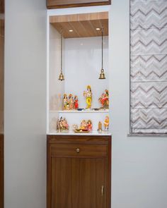 a shelf with some figurines on top of it next to a wall mounted light