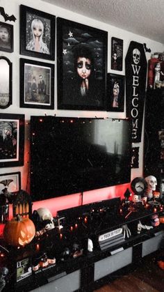 a living room decorated for halloween with pictures and decorations on the wall, including a flat screen tv