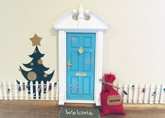 a blue door with a red bag next to it and a christmas tree on the wall