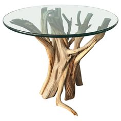 a glass table with driftwood in the shape of a tree branch on it's base