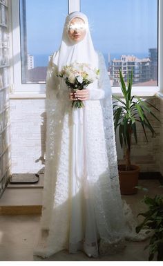 a woman in a white veil holding flowers