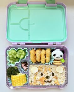 a bento box filled with rice, meat and veggies on top of it