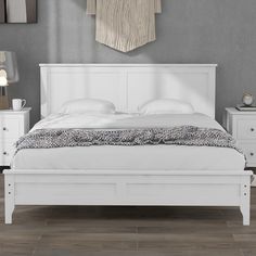 a white bed with two night stands on each side