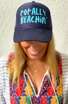 TOTALLY BEACHIN' in aqua on a navy trucker hat with interior french terry sweat band and adjustable snap back. Casual Beach Baseball Cap With Letter Print, Casual Trucker Hat With Uv Protection Snapback, Casual Snapback Trucker Hat With Uv Protection, Summer Lightweight Snapback Trucker Hat, Navy Snapback Trucker Hat For Summer, Lightweight Snapback Trucker Hat For Summer, Spring Vacation Trucker Hat, Blue Baseball Cap For Summer Vacation, Casual Navy Baseball Cap For Summer