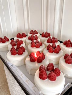 there are many small cakes with raspberries on the top and one candle in the middle