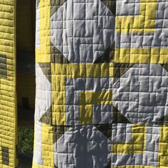 a yellow and white quilt on the side of a building