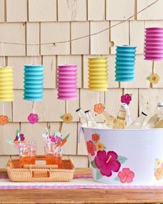 a table topped with lots of bottles and paper lanterns hanging from the side of it