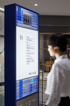 a woman walking past a display in an office building