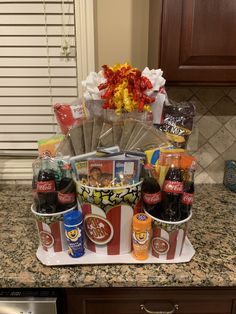 a basket filled with sodas and snacks on top of a counter