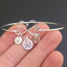 "Family Infinity Heart Bracelet - Personalized Mother's Day Gift Jewelry Choose infinity heart charm in sterling silver or 14k gold filled to be transformed into a personalized family bracelet with the initials of family members and bangle band in matching finish. Please mention initials in notes to seller during checkout. The first initial charm dangles from the heart in the middle. I can stamp parent's or couple's initials, mom's initial or guardian's initials, or grandparent's initials. I can Sterling Silver Bracelet Jewelry Gift, Nickel Free Jewelry For Anniversary On Valentine's Day, Valentine's Day Anniversary Bangle Bracelets, Adjustable Sterling Silver Charms Jewelry, Valentine's Day Anniversary Bangle Bracelet, Elegant Adjustable Open Heart Jewelry, Elegant Nickel-free Name Bracelet For Mother's Day, Hand Stamped Double Heart Sterling Silver Jewelry, Minimalist Bangle Jewelry For Valentine's Day