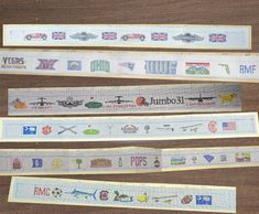 four rolls of washi tape with different types of logos and symbols on them sitting on a wooden surface