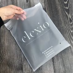 a person holding onto a clear plastic bag with the word elexo on it