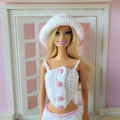 a doll wearing a white crocheted outfit and hat