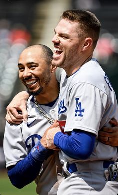 two baseball players are hugging each other on the field