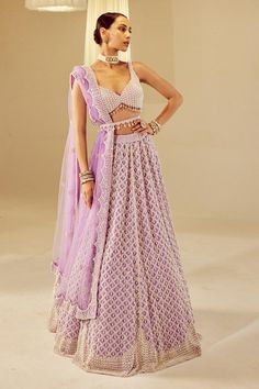 Lilac attached cancan lehenga with pearl drop embellishments. Comes with heavily embellished sweetheart neck padded blouse and dupatta.
Components: 3
Pattern: Embellished
Type Of Work: Pearls
Neckline: Sweetheart
Sleeve Type: Sleeveless
Fabric: Blouse and Lehenga: Georgette, Dupatta: Net, Lining: Silk Blend
Color: Purple
Other Details: 
Tassel hem blouse
Lehenga length: 46 inches
Note:
Belt worn by the model and the lehenga set worn by the other model on the back is not for sale.
Kindly contact Purple Sleeveless Wedding Set, Sleeveless Cutdana Choli For Wedding, Fitted Net Choli With Cutdana, Net Lehenga For Reception, Fitted Net Sharara With Cutdana, Wedding Choli With Cutdana On Net Material, Wedding Choli With Cutdana On Net, Bollywood Style Choli With Lace Work For Designer Wear, Bollywood Style Choli With Lace Work