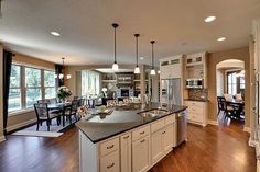 a large kitchen with an island in the middle and lots of windows on both sides