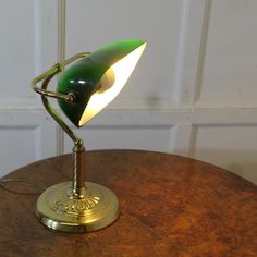 a green lamp sitting on top of a wooden table