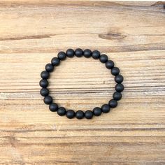 This beaded bracelet has 8mm matte black beads on a clear elastic cord. A smooth matte finish gives the bracelet a sleek modern look making it a good gift for the men in your life. It is a minimalist-style unisex stretch bracelet making it a good choice for men, and teens. The stretchy design allows for easy comfortable wear.  The bracelet comes with a care card and a storage pouch. You can also leave a gift message to be sent with your order.  Gift Wrap Upgrade is available at checkout and incl Classic Black Bracelets With 8mm Beads, Hypoallergenic Black Round Bracelets, Minimalist Black Stretch Bracelet With Round Beads, Minimalist Black Wristband With Round Beads, Black Hypoallergenic Beaded Bracelets, Hypoallergenic Black Beaded Bracelets, Black Hypoallergenic Stretch Bracelet With Round Beads, Mens Bracelet Black, Black Onyx Bracelet