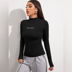 Mock Neck, “Feelings” Fitted Tee. Size: L (Personally I Think It Will Fit Better As Size M) Length: 25 Inch Waist: 31.1 Inch Bust: 35.4 Inch Slim Fit. Slight Stretch Trendy High Stretch Tops With Letter Print, Casual Black Turtleneck T-shirt, High Stretch Casual High Neck Tops, Casual High Neck High Stretch Tops, Casual High Neck Tops With High Stretch, Stretch High Neck Top With Graphic Print, Winter Stretch Tops With Letter Print, Fitted Winter T-shirt With Letter Print, Casual High Neck Stretch T-shirt