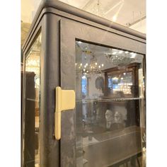 an old metal cabinet with glass doors and knobs on the front, in a store