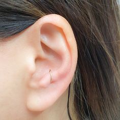 a woman's ear is shown with a tiny nose ring