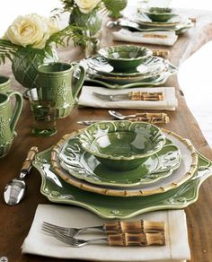 the table is set with green dishes and silverware