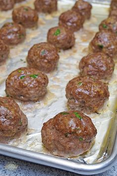 some meatballs are sitting on top of tin foil and ready to be cooked in the oven