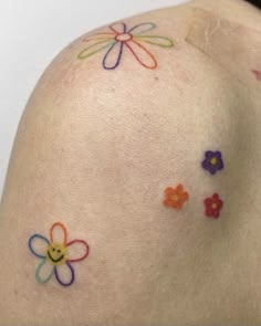 the back of a woman's shoulder with flowers painted on her arm and chest