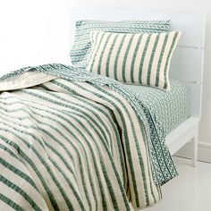 a bed with green and white striped sheets