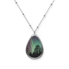 "Stunning and unique one-of-a-kind Aurora Borealis oval nature inspired necklace features a nature photography print of The Northern Lights. The unique nature photography silver pendant and its longer length adjustable specialty chain are made with a robust zinc-alloy blend for a dazzling look and feel. The pendant, shaped in the form of an ellipse and the 20\" adjustable silver chain is embellished with beading and a lobster clasp closure. Pendant art features an original Northern Lights photography print with a beautiful glossy finish.  Makes a thoughtful gift for a photography or nature lover.  Pendant height: 1.5 inches Pendant width: 1 inch Chain length: 20.47 inches" Nature-inspired Oval Jewelry With Large Pendant, Silver Nature-inspired Teardrop Pendant Necklace, Silver Teardrop Pendant Necklace Nature-inspired, Sterling Silver Oval Necklace With Nature-inspired Style, Nature-inspired Necklace With Large Oval Pendant, Nature-inspired Engraved Oval Pendant Necklaces, Nature-inspired Engraved Oval Pendant Necklace, Nature-inspired Oval Engraved Necklaces, Nature-inspired Oval Engraved Necklace