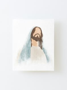 the face of jesus painted in watercolor on a canvas mounted to a white wall