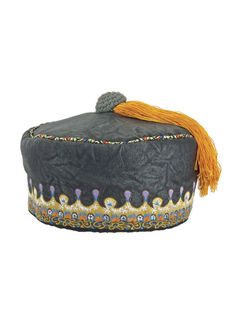 a black hat with orange tassels and beads on the top, sitting against a white background