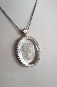 Large ART DECO intaglio reverse carved glass crystal oval cameo pendant necklace with Roman Greek goddess lady portrait and silver color metal frame and chain with clasp - vintage . Pendant:  inches (without bail); 3/8 inches width; chain:  inches. Good vintage condition - sold as is -return not accepted.  To make this a smooth and pleasant transaction experience for everyone, all buyers need to read and understand the description, the terms of sale , the payment and the shipping indicated in this listing. Return and cancellations not accepted - please ask all your questions before purchase. Elegant Oval Pendant Necklace For Collectors, Cameo Pendant For Jewelry Making, Elegant Cameo Round Pendant Jewelry, Cameo Oval Pendant Jewelry For Anniversary, Ornate Cameo Jewelry For Anniversary, Ornate Oval Cabochon Necklaces, Elegant Carved Oval Jewelry, Ornate Oval White Gold Necklaces, Elegant Oval Carved Jewelry