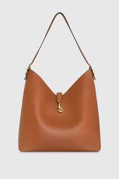 The Megan Hobo is the ideal go-to bag for those seeking effortless style and functionality. Crafted from genuine leather, this spacious hobo is designed to fit all your essentials while maintaining a sleek and modern silhouette. Its magnetic snap closure and antique brass hardware add a touch of sophistication, making it a perfect choice for everyday wear. Style # HH24TMGHOB-CARAMELLO 100% Genuine Leather Antique Brass Hardware 13" W X 14. 5" H X 6. 25" D 23" Strap Drop Magnetic Snap Closure 1 B Classic Hobo Bag With Removable Pouch For Errands, Everyday Use Bucket Shoulder Bag With Gold-tone Hardware, Gold-tone Bucket Shoulder Bag For Daily Use, Cognac Bag With Gold-tone Hardware For Errands, Versatile Hobo Bag With Gold-tone Hardware For Shopping, Everyday Rectangular Hobo Bag With Gold-tone Hardware, Cognac Bag With Gold-tone Hardware For Shopping, On-the-go Cognac Hobo Bag With Removable Pouch, Daily Use Hobo Bag With Gold-tone Hardware