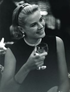 a black and white photo of a woman holding a wine glass in her right hand