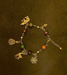 "A bracelet specially designed with the season of Yule in mind. Crystals: Garnet & Bloodstone. Charms: Bran, Pine Tree, Stag, Snowflake, Pine Cone. Other beads: Firepolish bead in gold. Please note Bloodstone naturally varies in color. Bracelet is 9in total but can be closed starting at 7 3/4in. Crystals, animals, colors and symbols correspondences researched and carefully selected using Edain McCoy's \"Sabbats. A witch's approach to living the Old Ways\" and Llewellyn's Sabbat Essentials Collection. Stones, beads and charms cleansed with Sabbat appropriate incense.  Jewelry items are placed in a reusable muslin bag with beautifully scented dried lavender from my own garden, and lots of good vibes. Fill your muslin bag with additional herbs to toss in your bathtub for a beautifully scented