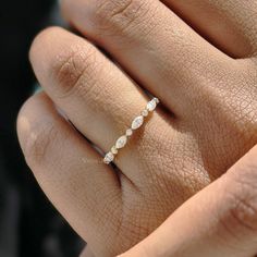 a woman's hand with a diamond ring on top of her finger, showing the band